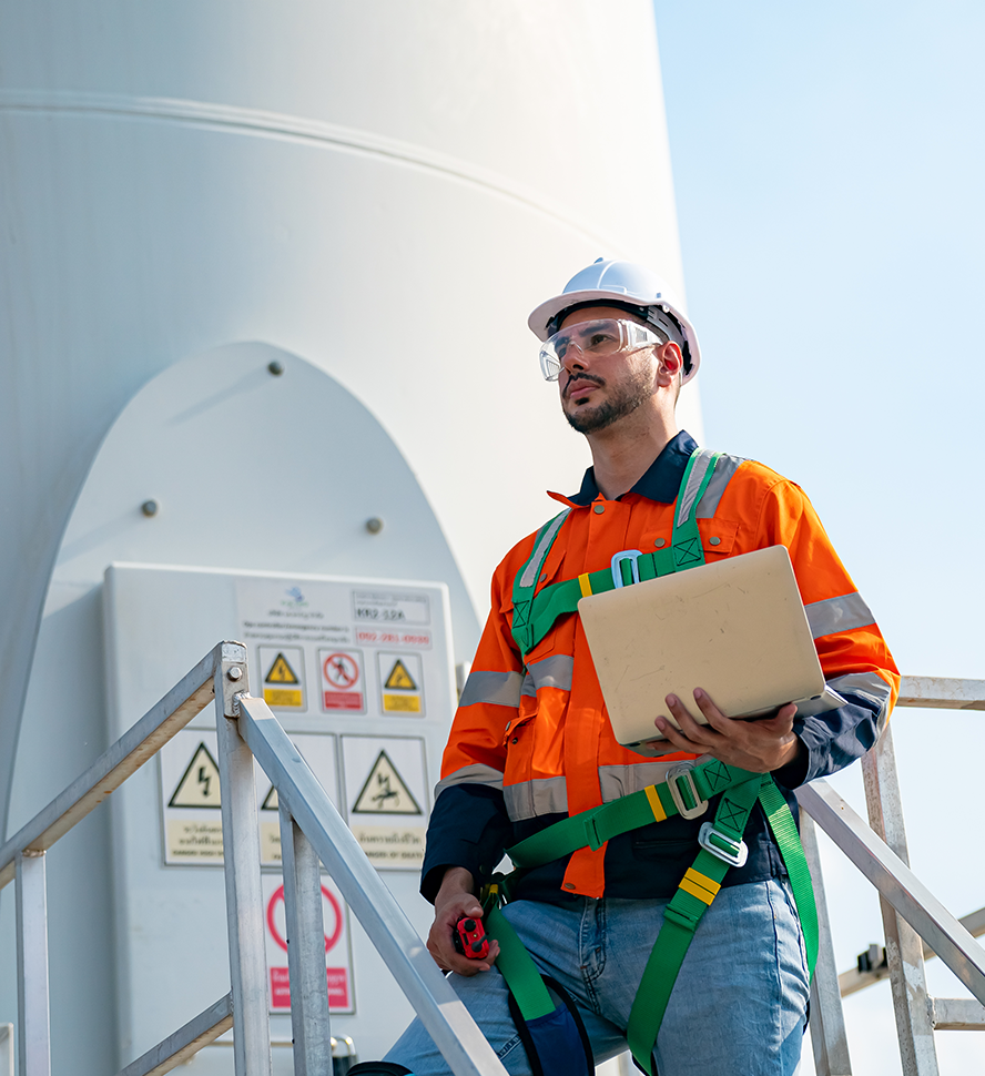 Industrial workers in hard hats reviewing a hazard assessment on site
